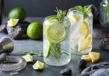 Hard seltzer cocktails with lime and lemon on a table. Summer refreshing beverage, drink